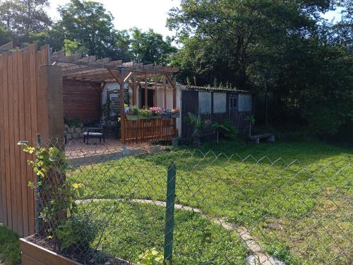une clôture dans une cour avec une cour arrière avec un hangar dans l'établissement Maison de campagne, à Saint-Éloy-les-Mines