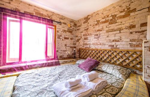 a bedroom with a large bed with towels on it at Loft Medieval Del Júcar in Alcalá del Júcar