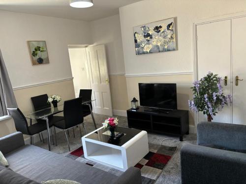 a living room with a couch and a tv at Zinoc Delight, free parking, at City centre, close to the sea & lovely places in Blythe