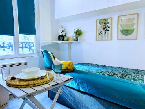 Cette chambre comprend un lit et une table avec des plaques de cuisson. dans l'établissement Le Mini Nook - Métro 9 Robespierre Porte de Paris, à Bagnolet