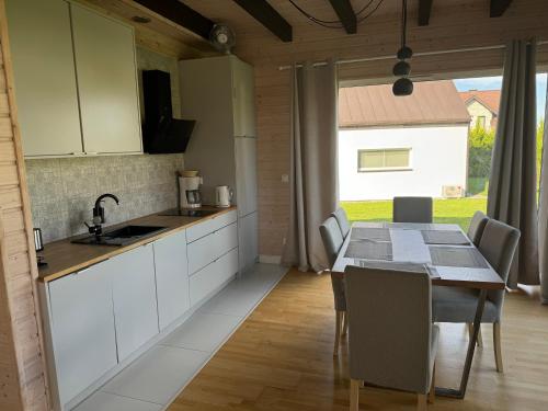 a kitchen and dining room with a table and chairs at Jaśminowy Sad in Mikołajki