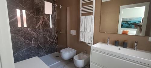 a bathroom with a toilet and a sink and a mirror at La casa di mest Pepp in Monopoli
