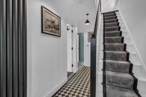 a staircase in a house with black and white floors at Stanley Park House Peterborough - 3 bed, 3 bathroom, parking, garden in Peterborough