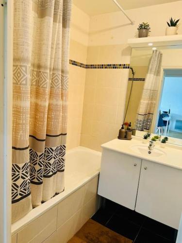 une salle de bain avec une baignoire, un lavabo et une douche dans l'établissement Charmant appartement près de la Défense et Paris, à Suresnes