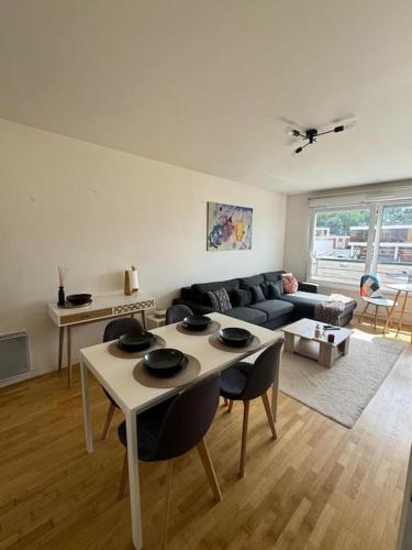 un salon avec une table et un canapé dans l'établissement Charmant appartement près de la Défense et Paris, à Suresnes