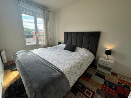 une chambre avec un grand lit et une fenêtre dans l'établissement Charmant appartement près de la Défense et Paris, à Suresnes