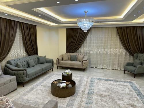 a living room with couches and a chandelier at شقة فندقية على النيل in Mansoura