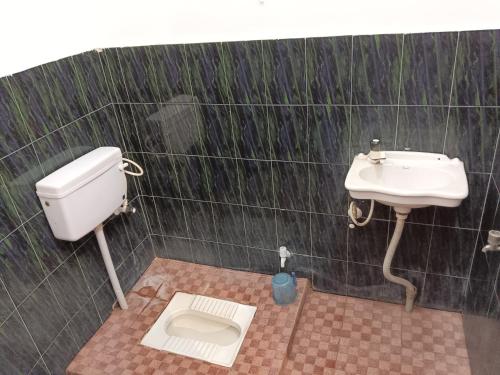 a bathroom with a toilet and a sink at Virat Palace in Deoghar