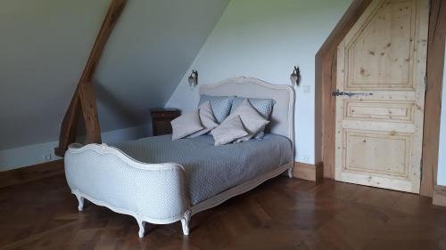 une chambre avec un lit blanc et un parquet dans l'établissement Le gite des pommiers, à Haudricourt