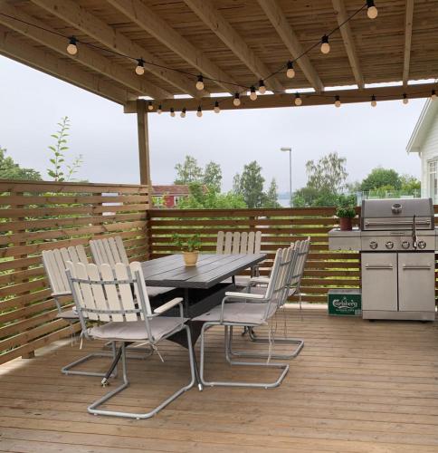 a patio with a table and chairs on a wooden deck at Ljusterö Logi in Norra Ljustero