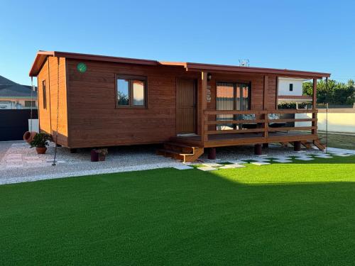 a house with a green lawn in front of it at Acolhedora casa de férias T2 com espaço exterior in Esmoriz