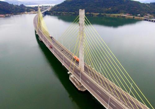 a large bridge in the middle of a body of water at Apartamento Mar grosso 100 metros do MAR in Laguna