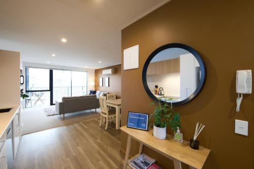 a living room with a mirror on a wall at Central City Apartments in Christchurch