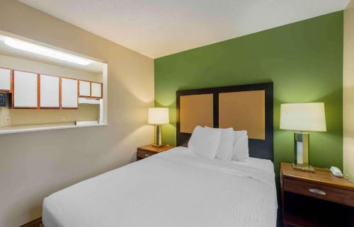 a bedroom with a white bed and green walls at Extended Stay America Suites - Omaha - West in Omaha