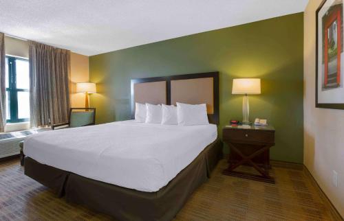 a hotel room with a large bed with white pillows at Extended Stay America Suites - Phoenix - Chandler in Phoenix