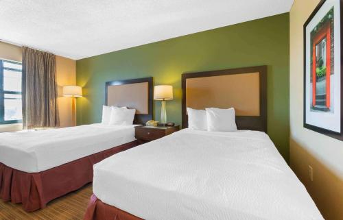 two beds in a hotel room with green walls at Extended Stay America Suites - Phoenix - Chandler in Phoenix