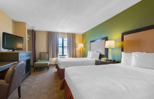 a hotel room with two beds and a flat screen tv at Extended Stay America Suites - Phoenix - Chandler in Phoenix