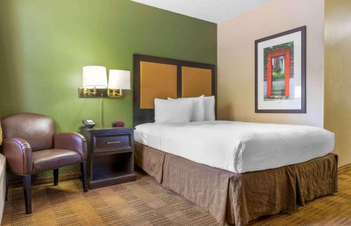 a hotel room with a large bed and a chair at Extended Stay America Suites - Bakersfield - California Avenue in Bakersfield