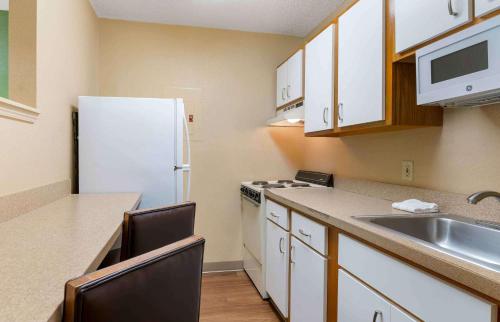 a kitchen with a white refrigerator and a sink at Extended Stay America Suites - Tallahassee - Killearn in Tallahassee