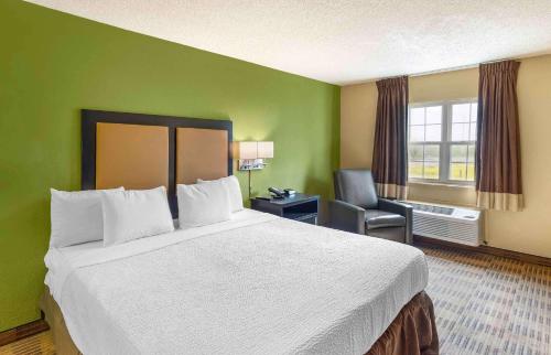 a hotel room with a large bed and a chair at Extended Stay America Suites - Sacramento - Northgate in Sacramento