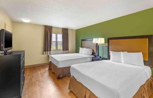 a hotel room with two beds and a flat screen tv at Extended Stay America Suites - Sacramento - Northgate in Sacramento