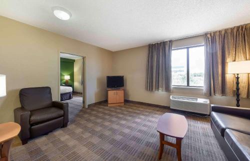 a hotel room with a couch and a chair and a television at Extended Stay America Suites - Tallahassee - Killearn in Tallahassee