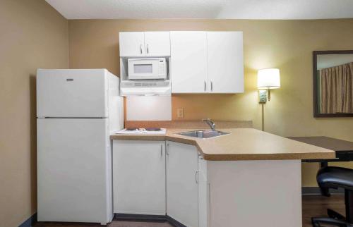 a kitchen with a white refrigerator and a microwave at Extended Stay America Suites - Mobile - Spring Hill in Mobile