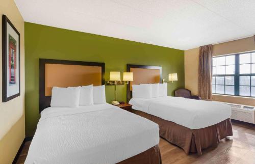 two beds in a hotel room with green walls at Extended Stay America Suites - Chicago - Elmhurst - O'Hare in Elmhurst