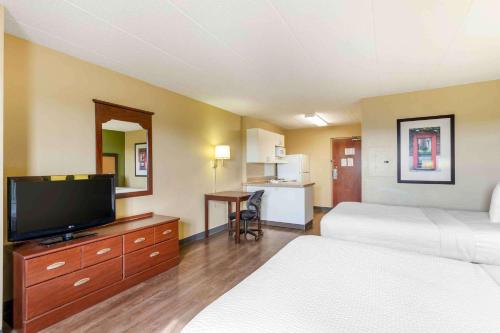a hotel room with two beds and a flat screen tv at Extended Stay America Suites - Chicago - Elmhurst - O'Hare in Elmhurst