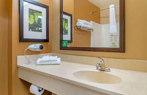 a bathroom with a sink and a mirror and towels at Extended Stay America Suites - Grand Rapids - Kentwood in Grand Rapids