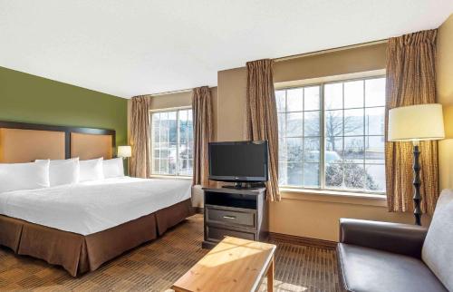 a hotel room with a bed and a television at Extended Stay America Select Suites - Chicago - Westmont - Oak Brook in Westmont