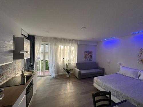 ナポリにあるF Rooms Napoli Via Sementiniのベッドルーム1室(ベッド1台、ソファ付)、キッチン