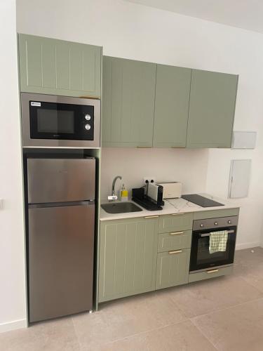 a kitchen with green cabinets and a stainless steel refrigerator at Galdós Flats by Vivo GC in Valencia
