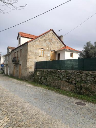a stone building next to a brick wall at Serra da Estrela - Casa Castro in Gouveia