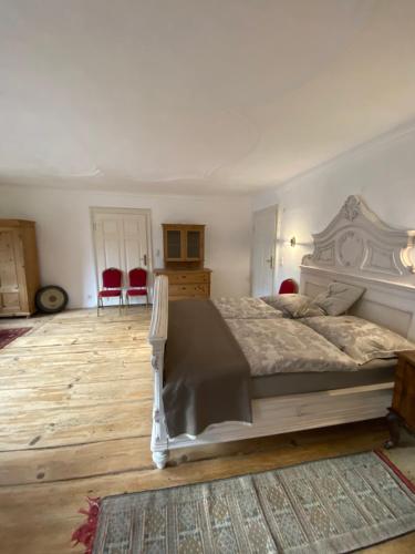a bedroom with a large bed and red chairs at Schlosstaverne Sighartstein Familienzimmer in Neumarkt am Wallersee