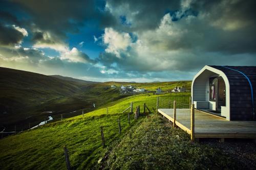 a small cabin on a hill with a view at SEApods - Isle of Lewis - Luxury en-suite pods on the edge of the Atlantic Ocean in Aird Uig