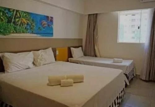 a hotel room with two beds and a window at Olímpia ao lado do Thermas in Olímpia