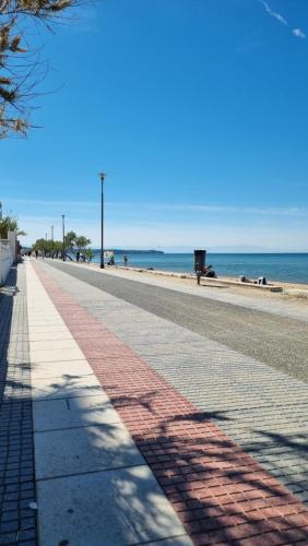 a sidewalk on the beach with the ocean in the background at Serenity Apartment in Perea