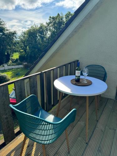a table and chairs on a deck with a bottle of wine at A fantastic hideaway in Blackwater for 4 people in Blackwater
