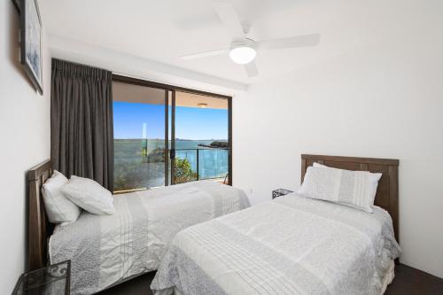 two beds in a bedroom with a large window at U3 10 Pac in Buddina