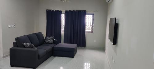 a living room with a couch and a tv at Purple Springs Elmina #2 in Brunibuma