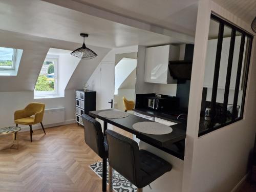 une cuisine et une salle à manger avec une table et des chaises dans l'établissement Appartement cosy, à Étampes