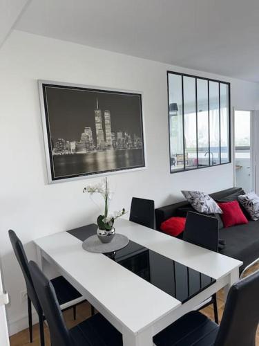 un salon avec une table et un canapé dans l'établissement Charmant T2 à Maisons Alfort - Tout meublé neuf, à Maisons-Alfort