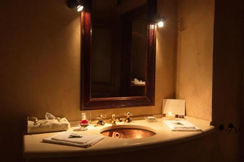 a bathroom with a sink with a mirror and towels at Imaret in Kavála