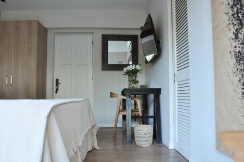 a bedroom with a bed and a table and a mirror at Le Bibló in Montevideo