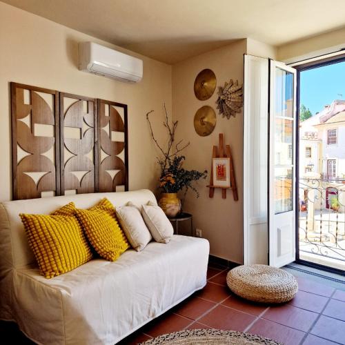 a living room with a white couch with yellow pillows at CASAS de CONSTÂNCIA in Constância
