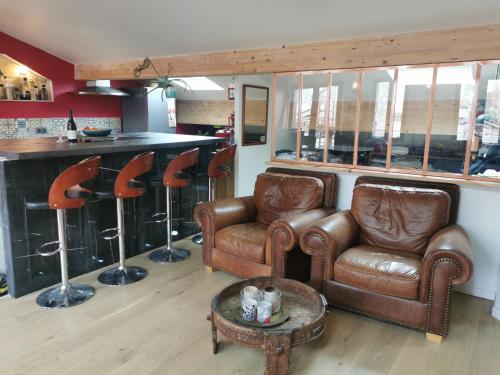 - un salon avec un canapé en cuir et un bar dans l'établissement Magnifique appartement sauna 100m2, à Bordeaux
