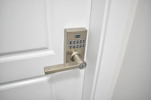 a white door with a metal door knob at Cozy escape! 2 BR Guest Suite! 2 Queen Beds! Complimentary WIFI Netflix & Parking! 11 Mins from YEG! 20 Mins from WEM! in Edmonton