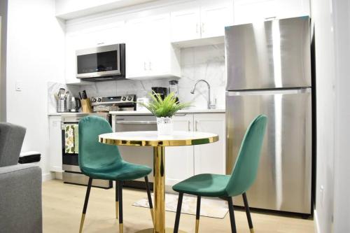 a kitchen with a table and chairs and a refrigerator at Cozy escape! 2 BR Guest Suite! 2 Queen Beds! Complimentary WIFI Netflix & Parking! 11 Mins from YEG! 20 Mins from WEM! in Edmonton