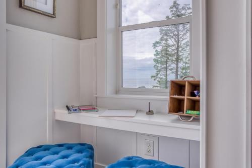 ein Fenster in einem Raum mit einem Schreibtisch und einem blauen Stuhl in der Unterkunft Coral Crest in Lincoln City